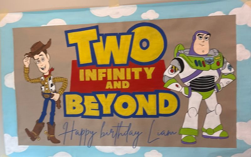 Handmade Toy Story birthday poster with Woody and Buzz on a sky of clouds, reading happy birthday Liam