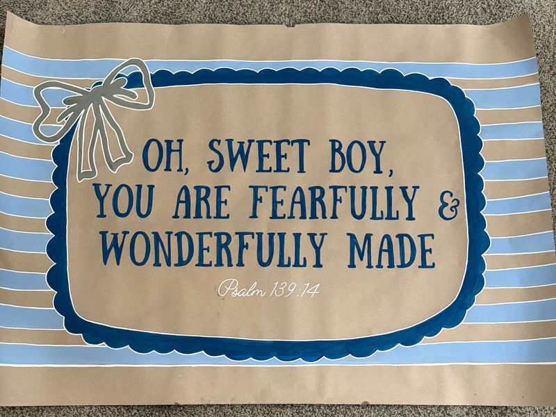 Handmade poster on kraft paper with blue stripes and a bow, reading oh sweet boy, you are fearfully and wonderfully made