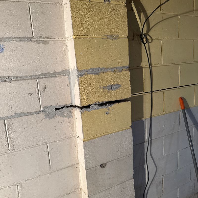 A crack running straight through a painted block wall